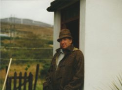 Hamilton sloan The Artist sporting a donegal tweed coat and hat outside the front door of Cottage Coshclady between Gweedore and Bunbeg county Donegal