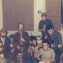 a group of us having a musical jam session in the fish factory hostel on the Vestmann island off the south coast of iceland in nineteen sixty five the instruments being played are two guitars bongo drums tin whistle saxophone and myself sporting donegal tweed hat and clarinet