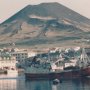 the harbour at heimaey in the vestmann islands showing fishing trawlers fish factories and the volcano which erupted in nineteen seventy three