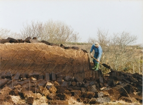 Irish man cutting a turf bank by himself